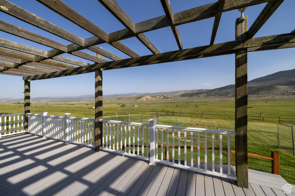 Deck featuring a view of countryside, a pergola, and a mountain view