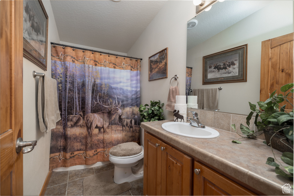Bathroom with vanity, curtained shower, and a textured ceiling