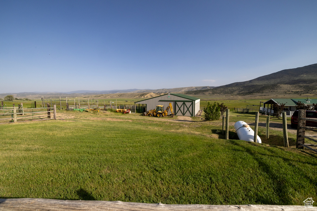 View of yard with a view of rural / pastoral area, an outdoor structure, an outbuilding, and a mountain view