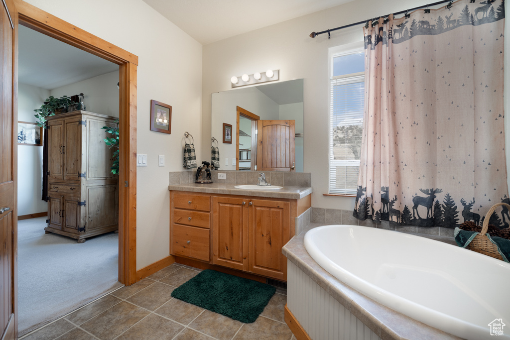 Full bathroom featuring vanity, a garden tub, tile patterned floors, and decorative backsplash