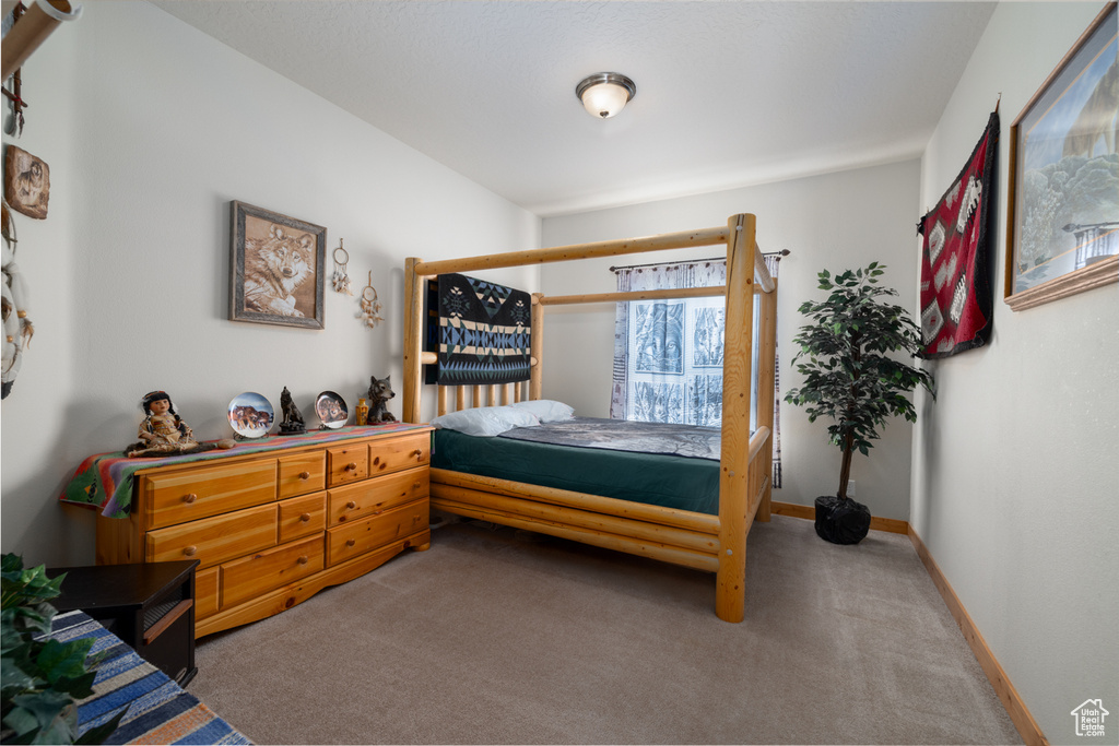 Bedroom featuring carpet and baseboards
