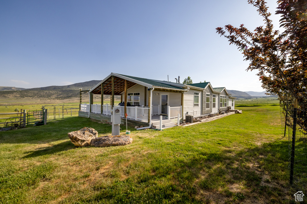 Rear view of property featuring a mountain view, a metal roof, and a rural view