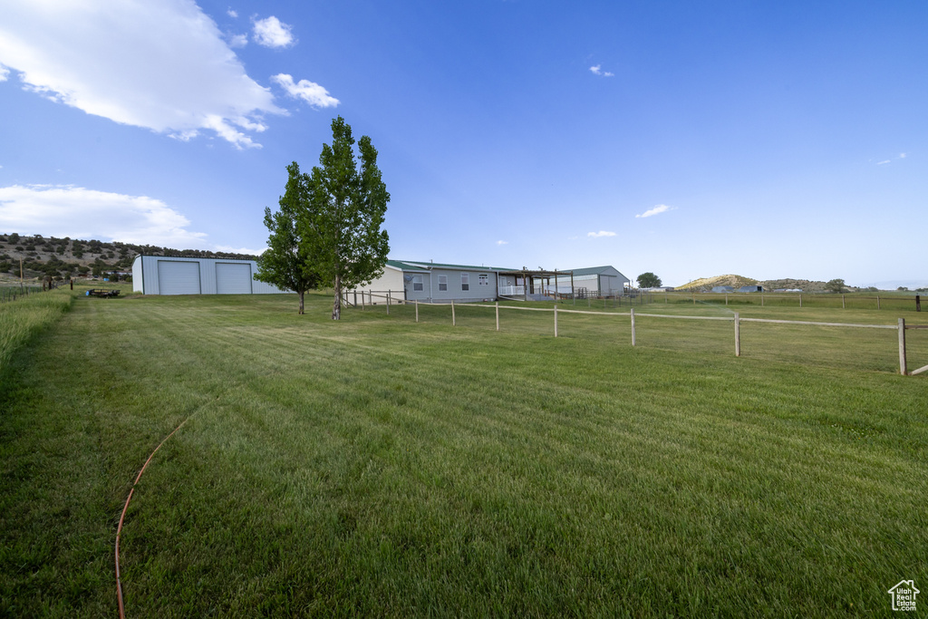 View of yard featuring a garage and a view of rural / pastoral area