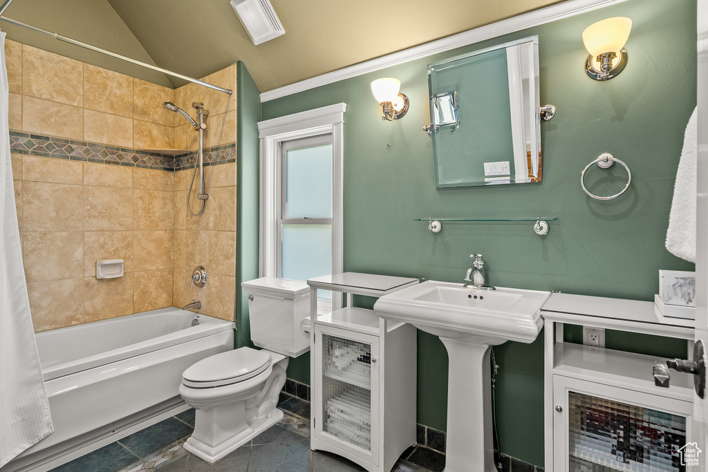 Full bathroom with shower / tub combo with curtain, ornamental molding, tile patterned flooring, and vaulted ceiling