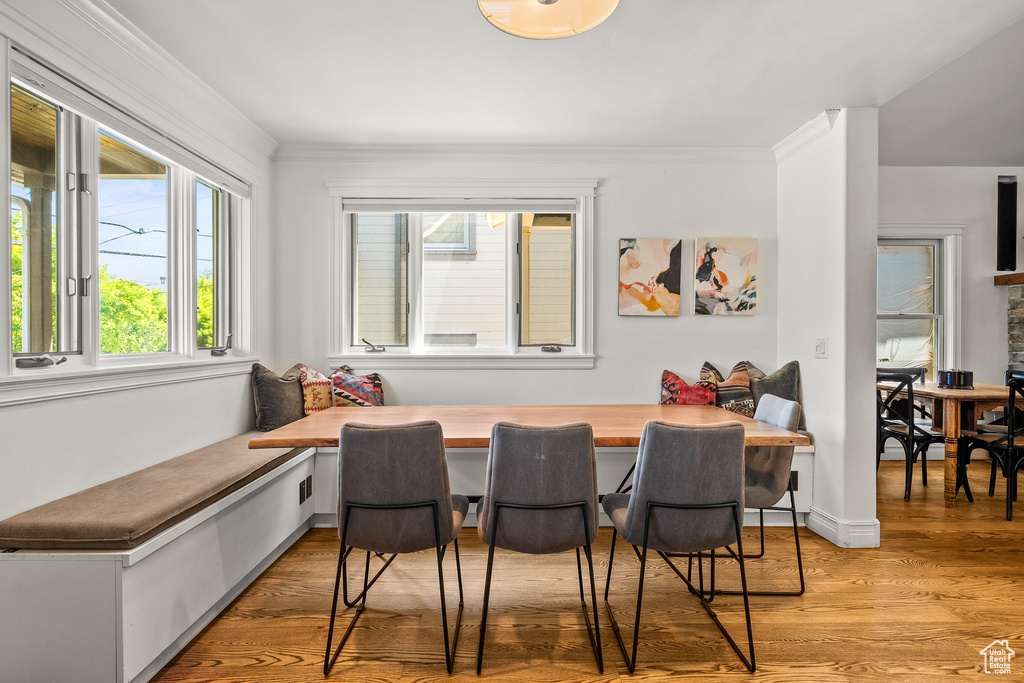 Dining room with breakfast area, light wood finished floors, and crown molding
