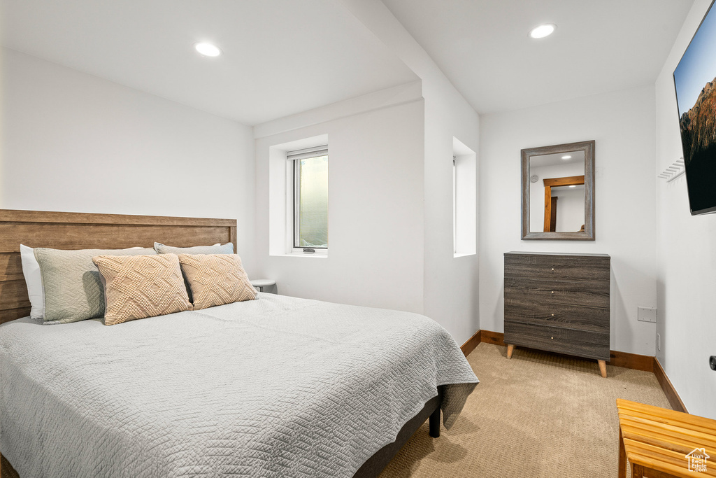 Bedroom with light colored carpet and recessed lighting