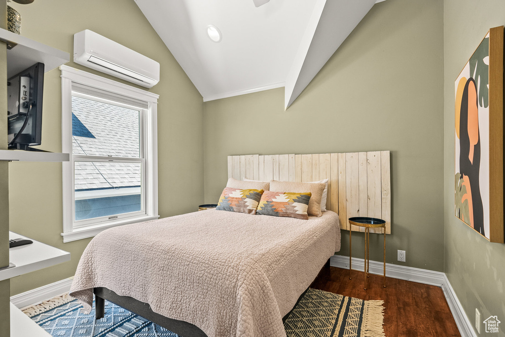 Bedroom with a wall unit AC, wood finished floors, and lofted ceiling