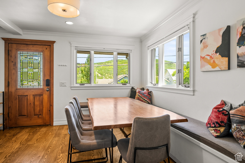 Dining space with light wood-style floors and ornamental molding