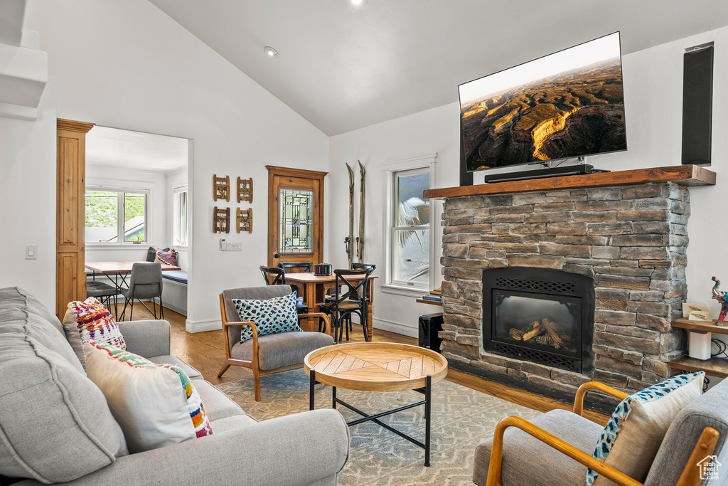 Living room featuring wood finished floors, a fireplace, recessed lighting, and high vaulted ceiling