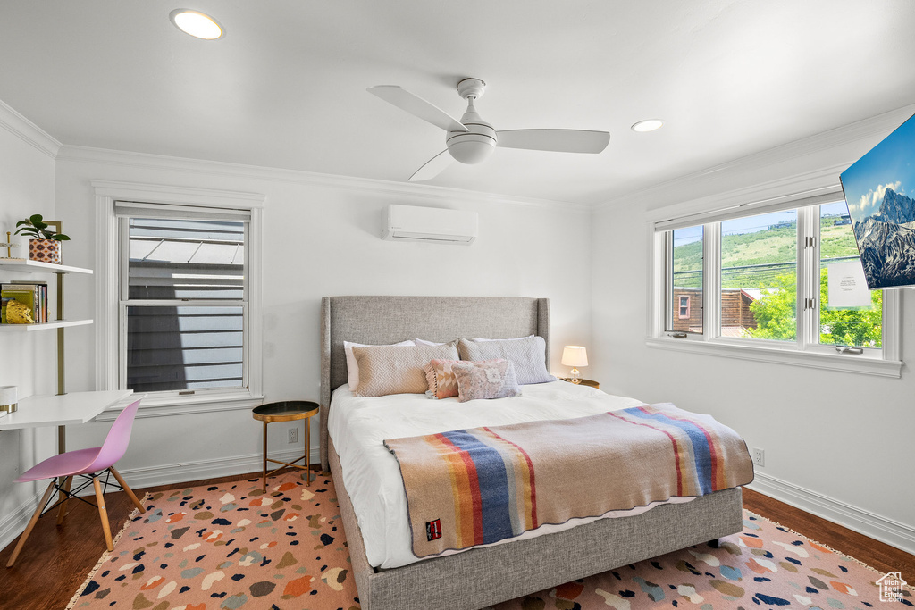 Bedroom with a wall mounted AC, crown molding, recessed lighting, wood finished floors, and ceiling fan