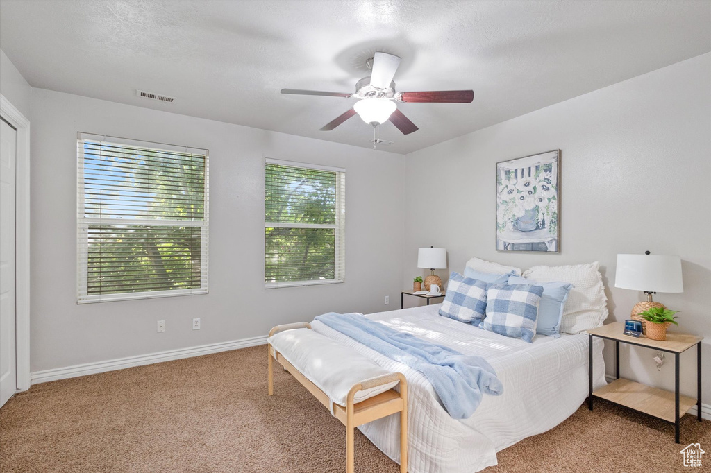 Carpeted bedroom featuring baseboards and ceiling fan