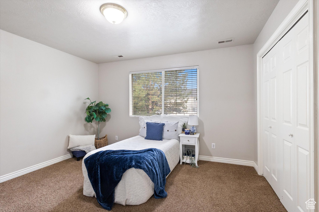 Carpeted bedroom with a closet