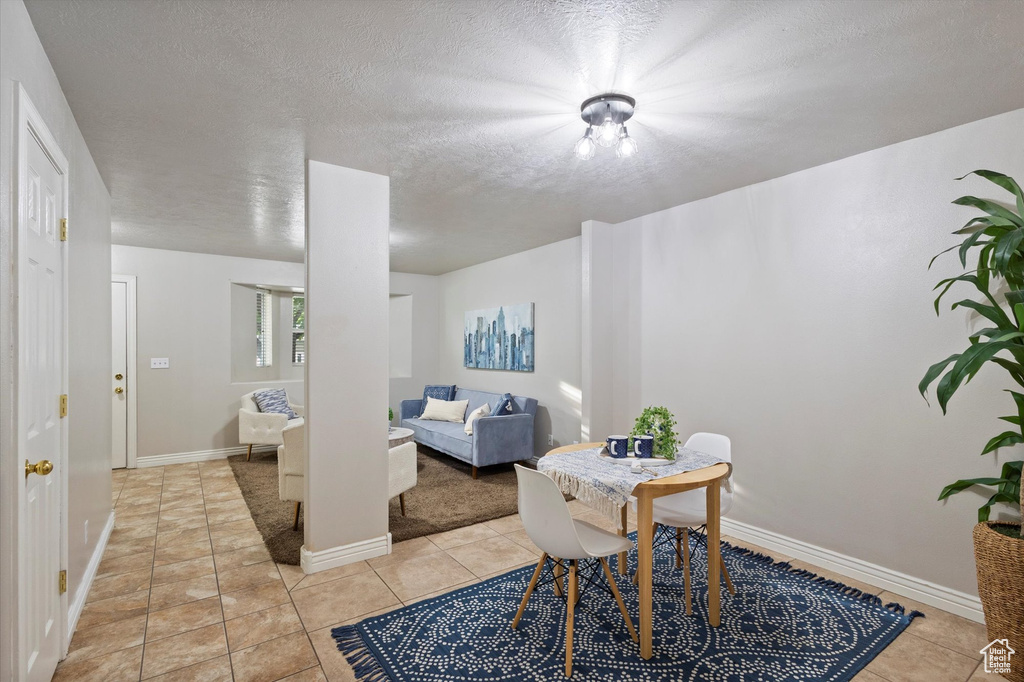 Dining area with light tile patterned floors and a textured ceiling