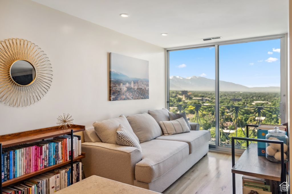 Living room featuring expansive windows, healthy amount of natural light, wood finished floors, a mountain view, and recessed lighting