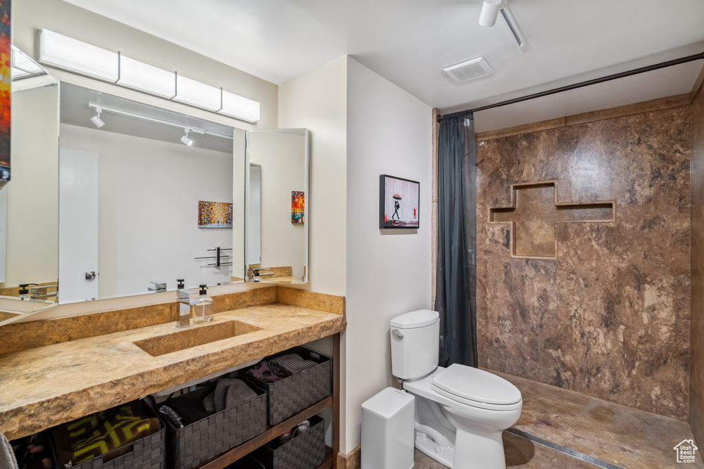 Bathroom featuring a shower with shower curtain and vanity