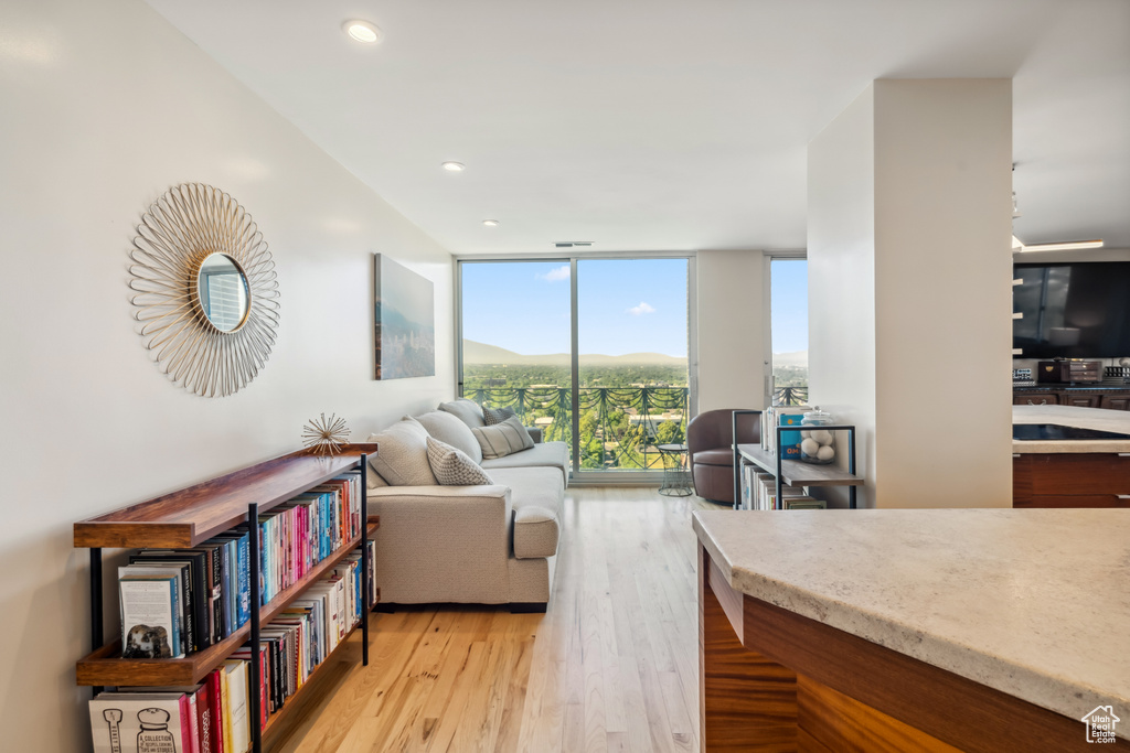 Living area featuring expansive windows, light wood finished floors, and recessed lighting