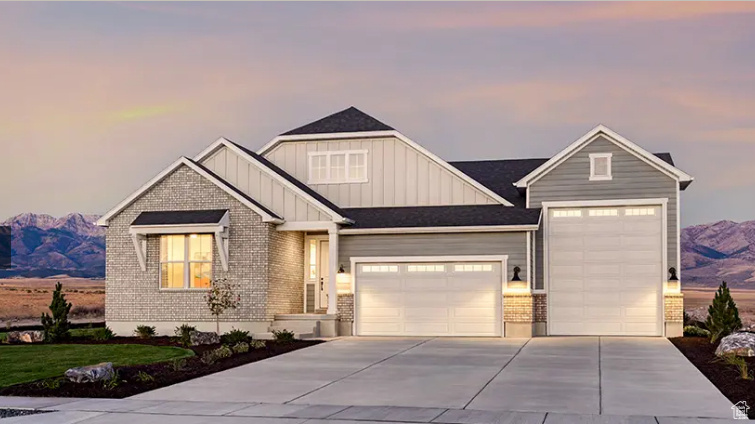 View of front of property featuring board and batten siding, an attached garage, driveway, and a mountain view