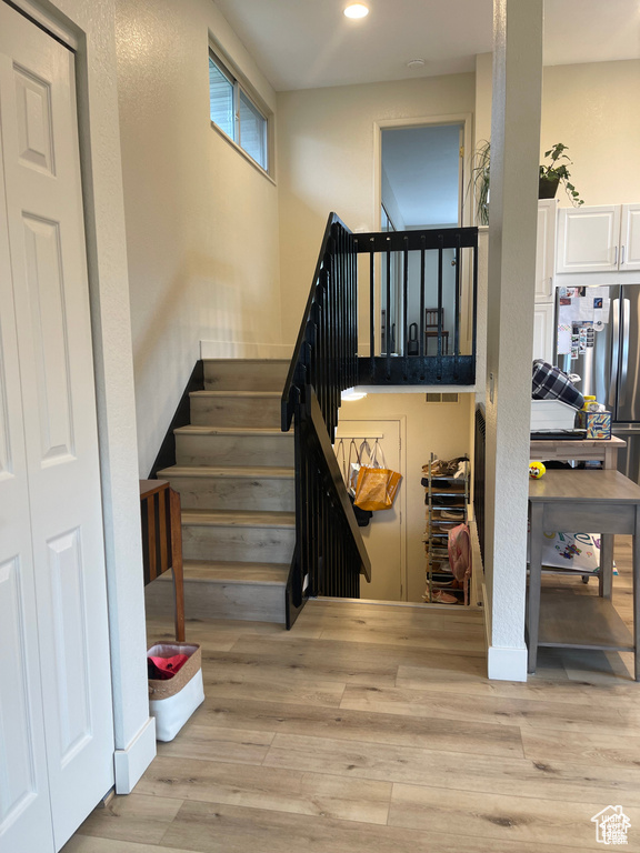 Staircase featuring wood finished floors and recessed lighting