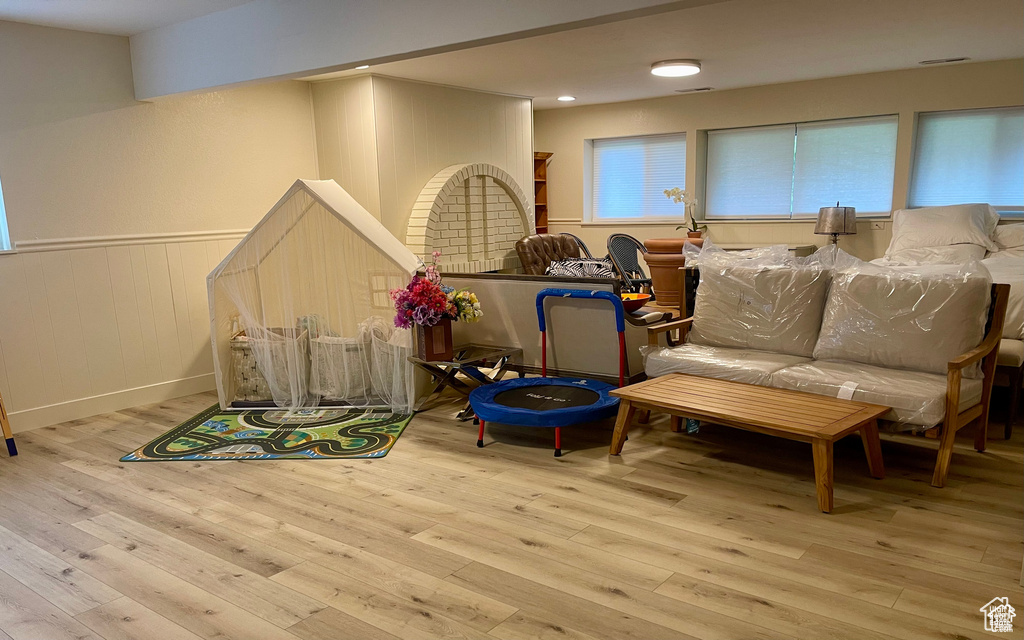 Recreation room featuring a wainscoted wall and wood-type flooring