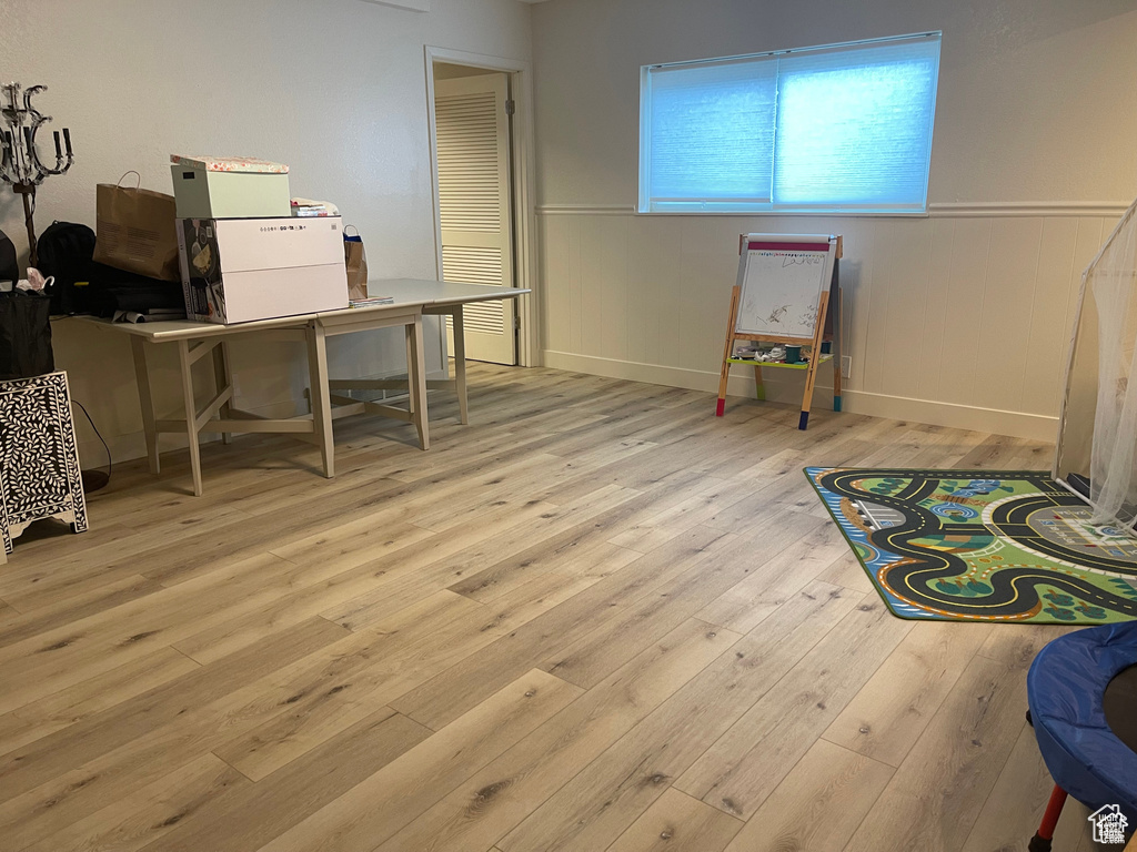 Recreation room with hardwood / wood-style floors, an office area, and a wainscoted wall