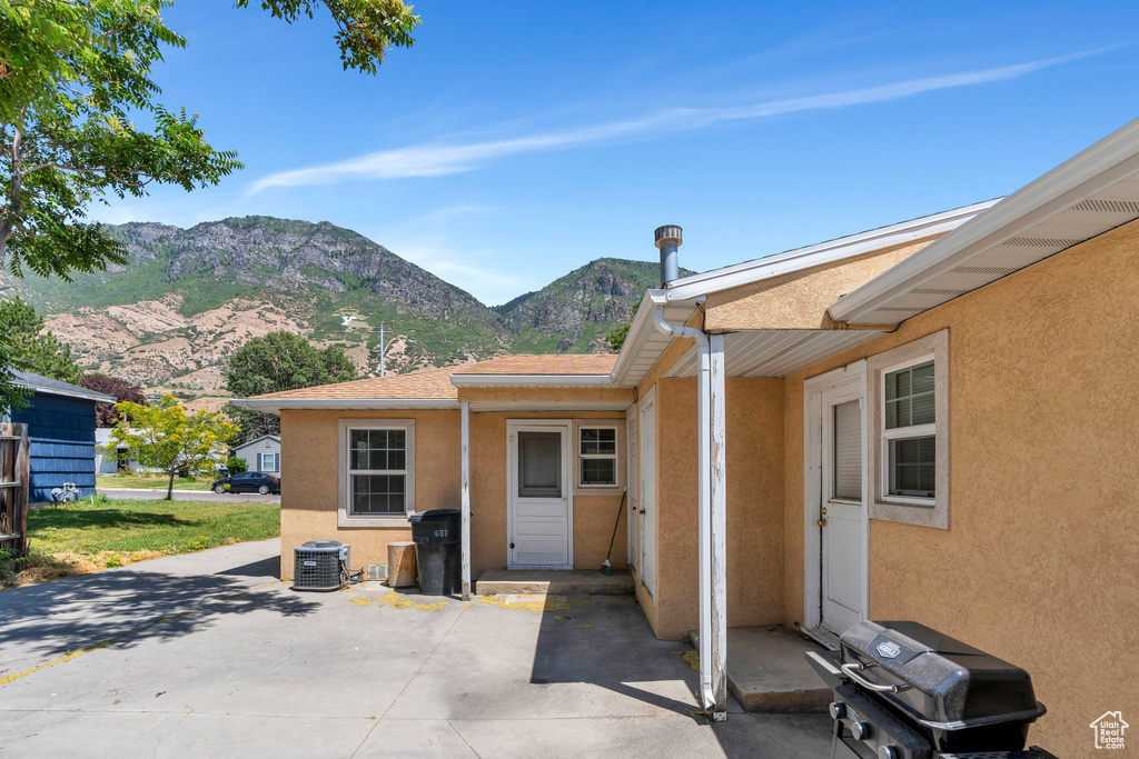 Doorway to property featuring stucco siding, a patio area, and a mountain view