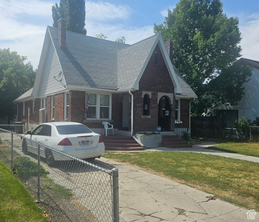 View of front of property with a chimney, brick siding, and a porch