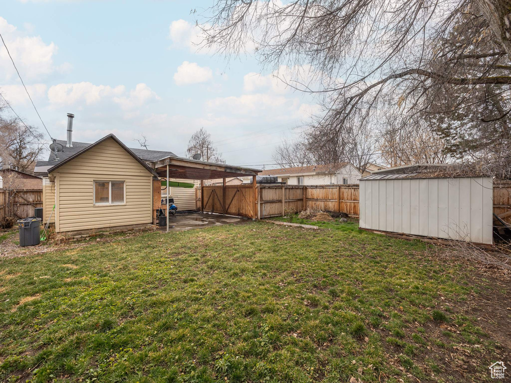 Fenced backyard featuring a shed