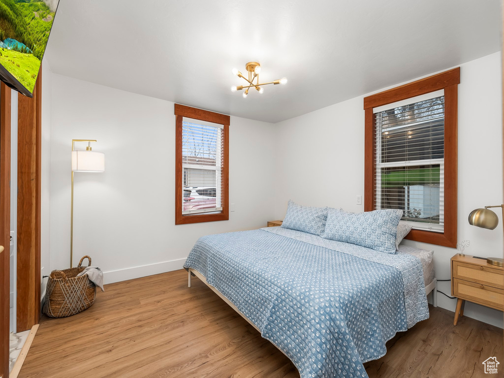 Bedroom featuring wood finished floors and a chandelier