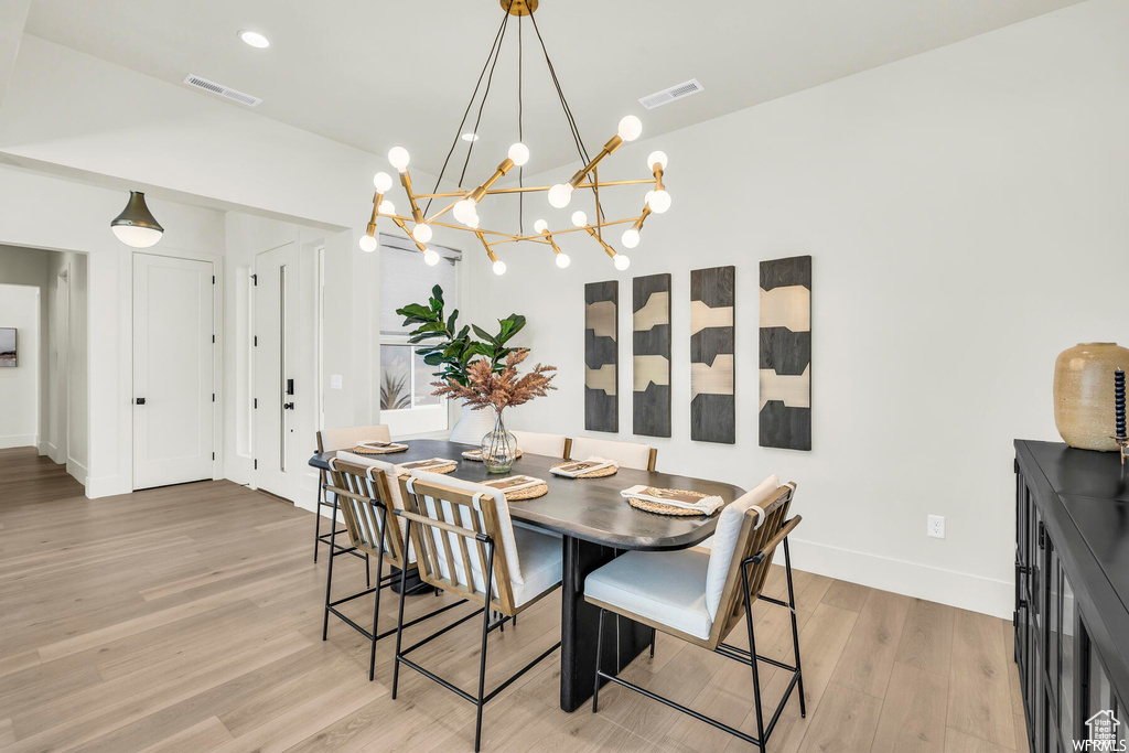 Dining space with light wood-style flooring and a chandelier