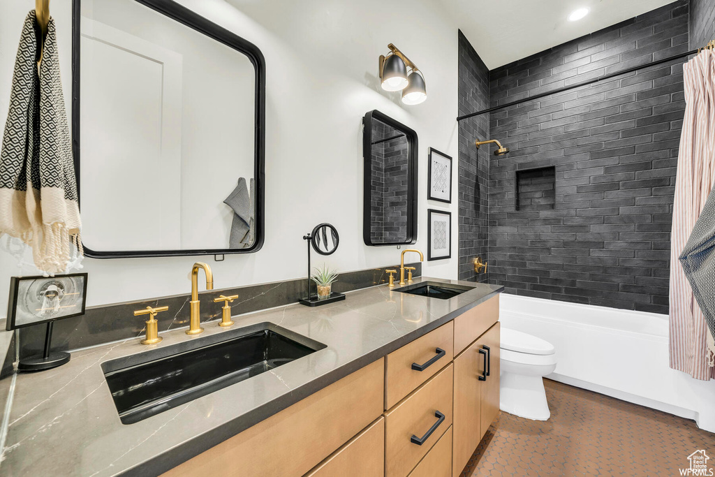 Full bathroom with double vanity, shower / bath combo, and recessed lighting