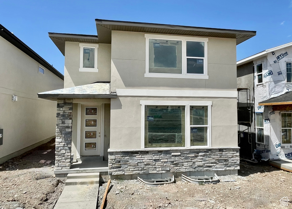 View of front of house with stone siding and stucco siding