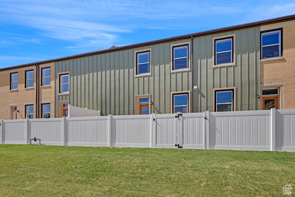 Rear view of property featuring a gate, board and batten siding, and a fenced backyard