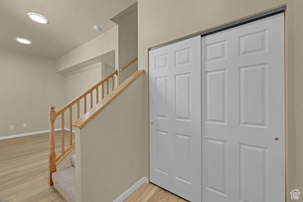 Stairs with wood finished floors and recessed lighting