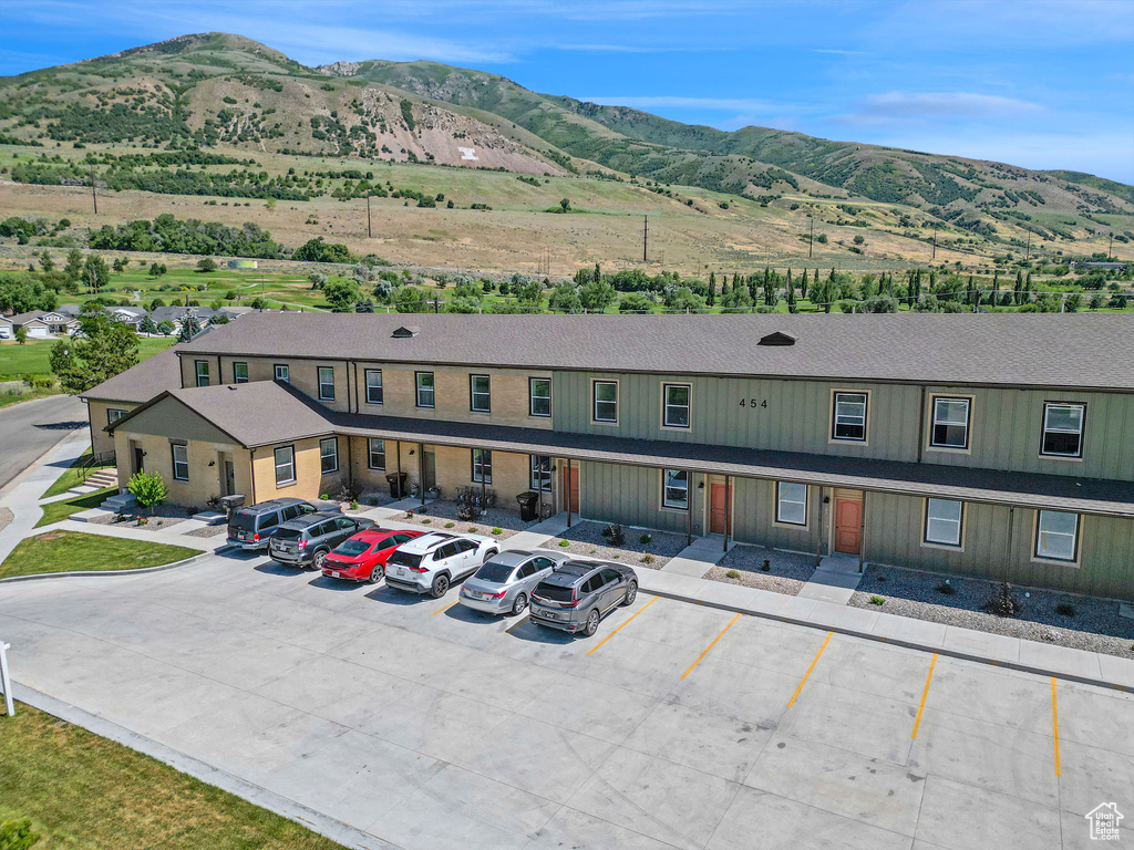View of building exterior with a mountain view and uncovered parking