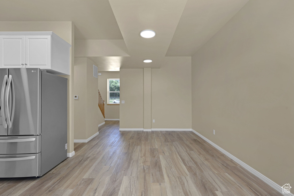 Empty room with light wood-style flooring and stairway