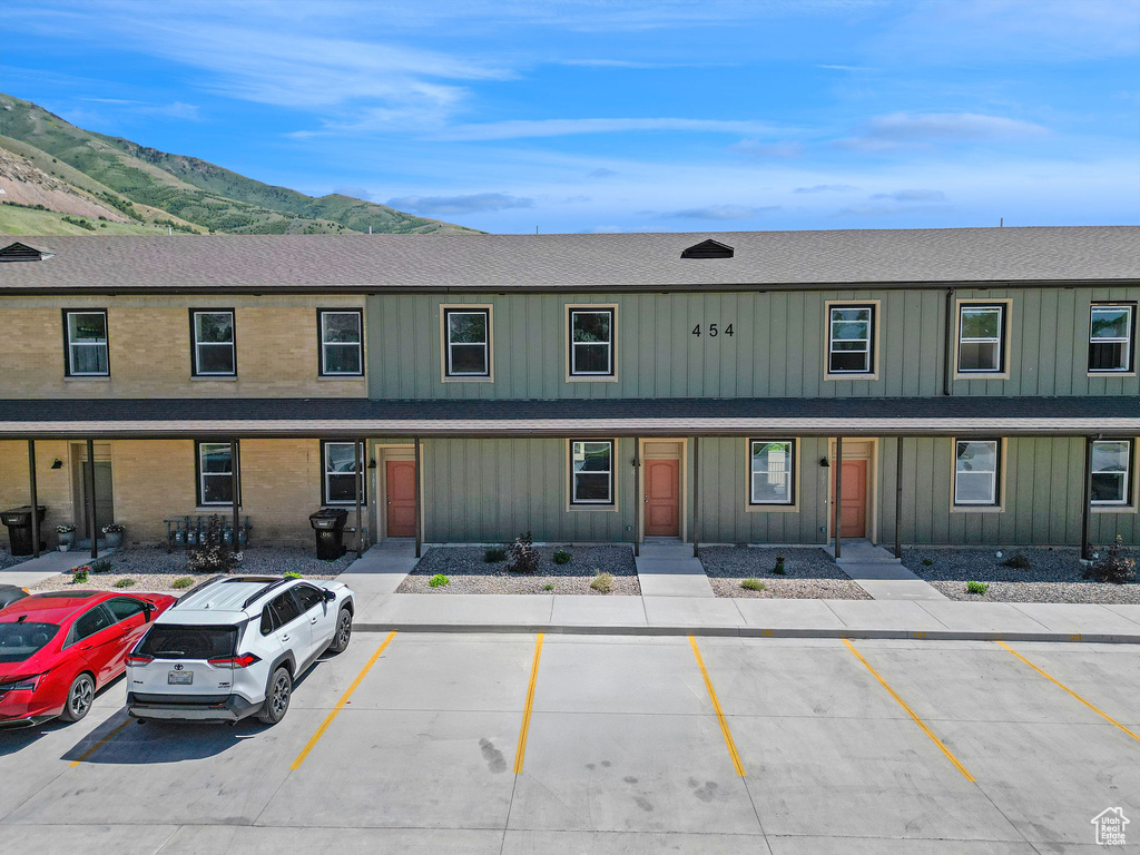 View of front facade featuring a mountain view, uncovered parking, and board and batten siding