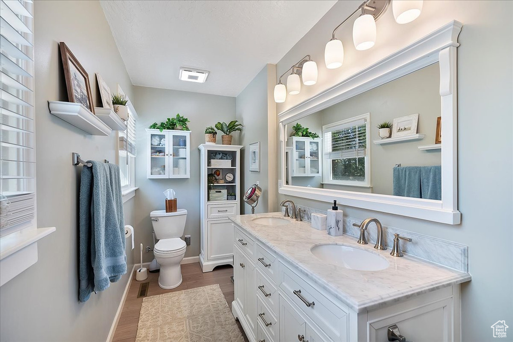 Full bath featuring wood finished floors and double vanity