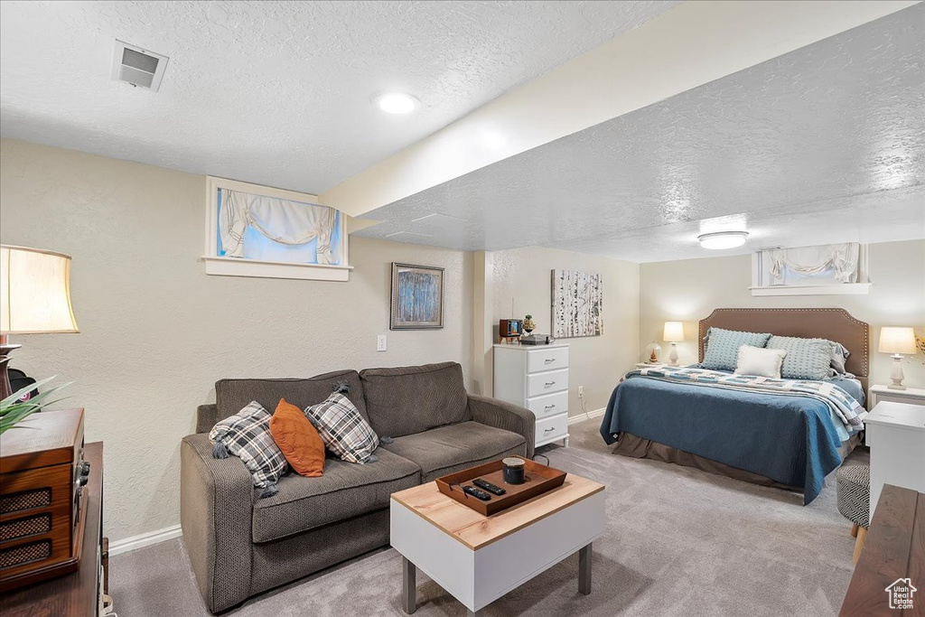 Bedroom featuring a textured ceiling, carpet floors, and a textured wall