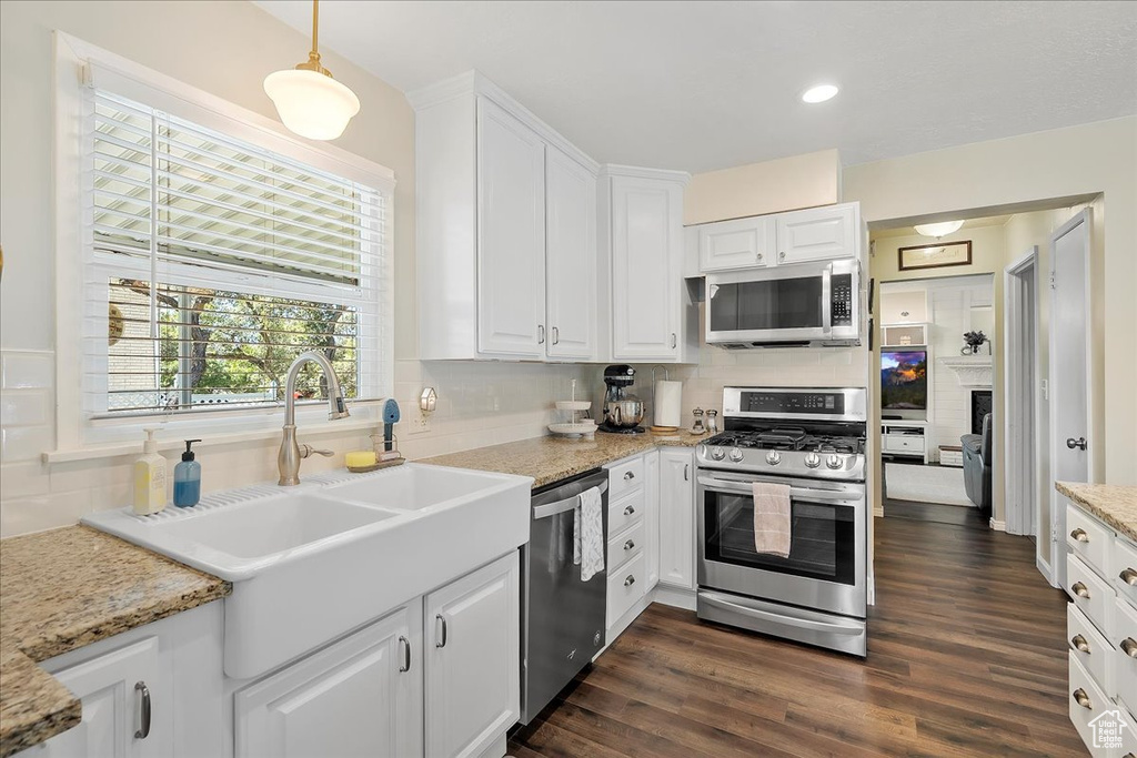 Kitchen featuring stainless steel appliances, tasteful backsplash, white cabinets, dark wood-style floors, and recessed lighting