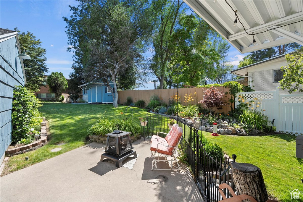 Fenced backyard with a patio area and a shed