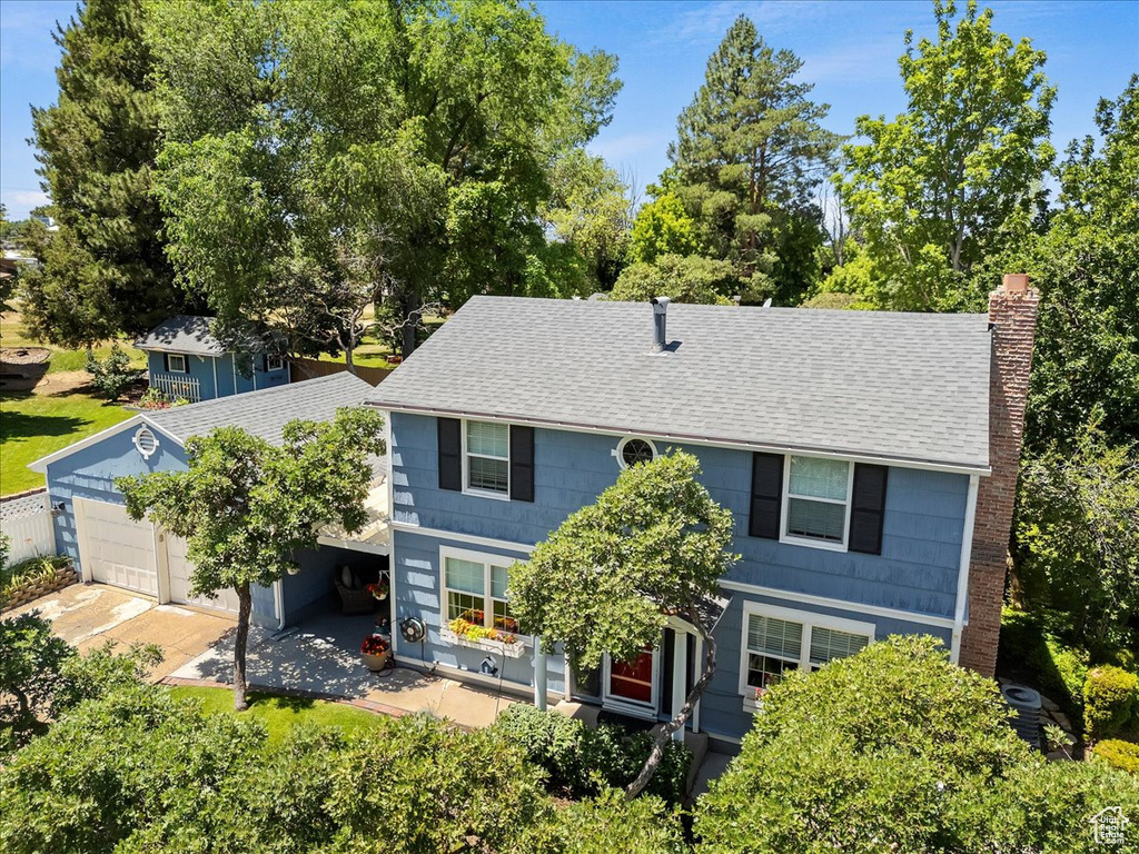 View of front of property with roof with shingles and a chimney
