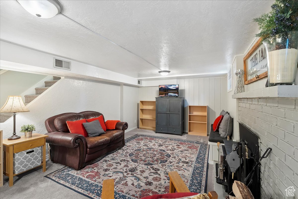 Living room with carpet floors, a textured ceiling, and stairway