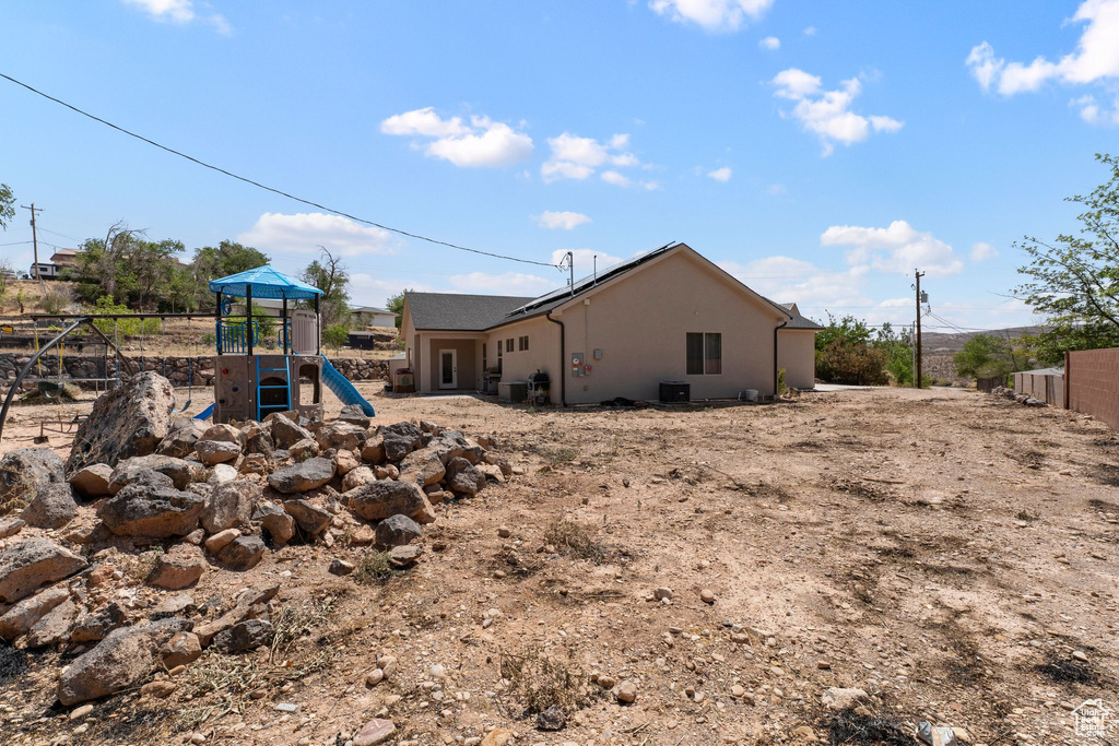 View of side of property with a playground and stucco siding