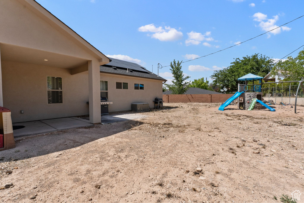 Fenced backyard featuring a playground