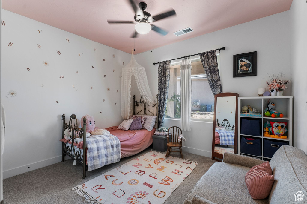 Carpeted bedroom featuring baseboards and ceiling fan