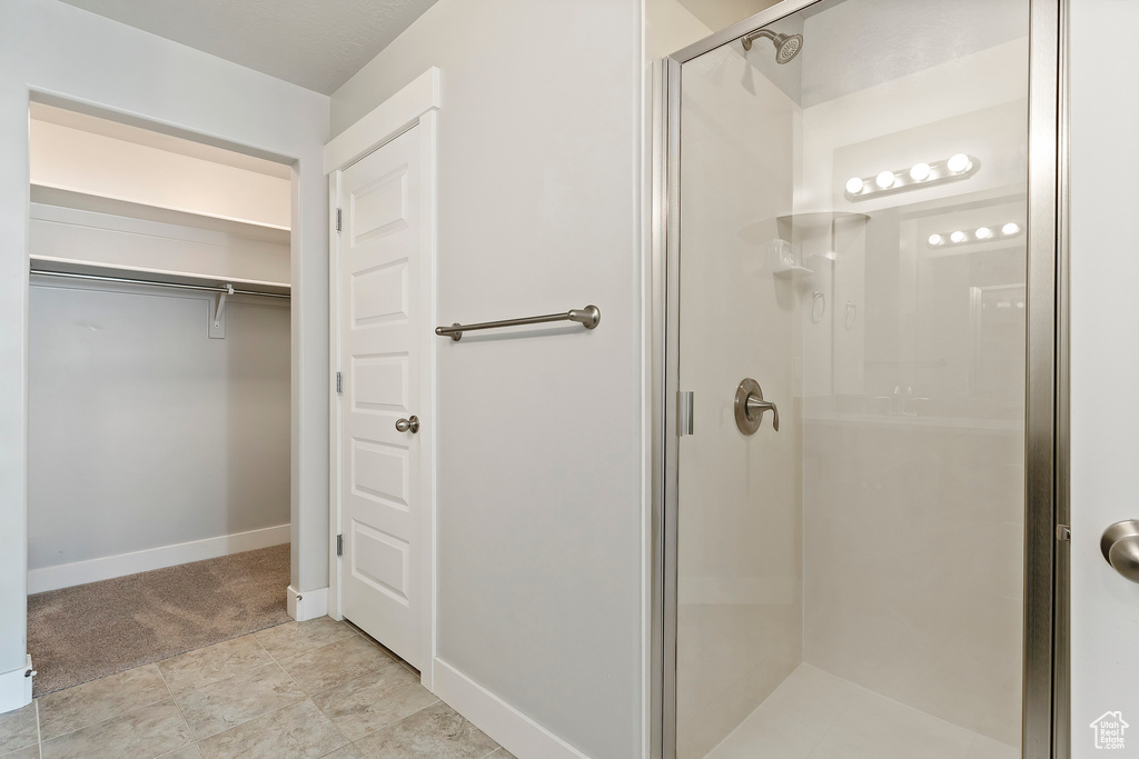 Full bathroom featuring a stall shower and a spacious closet