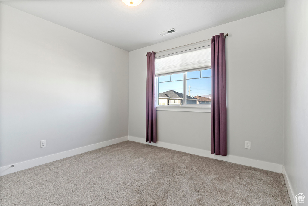 Carpeted empty room with baseboards