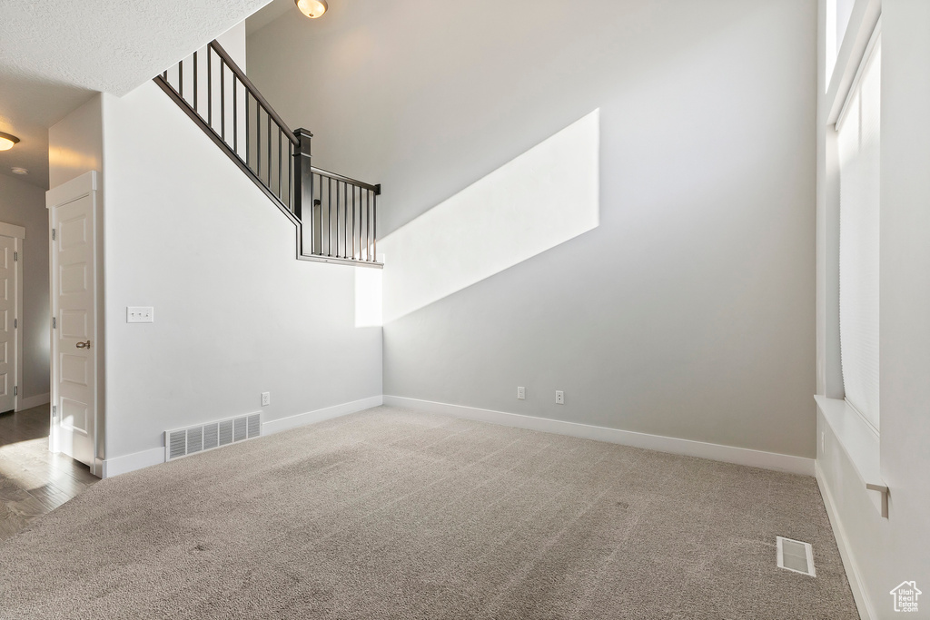 Unfurnished living room with carpet and baseboards