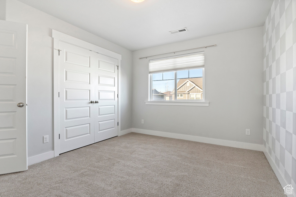 Unfurnished bedroom with carpet flooring and a closet