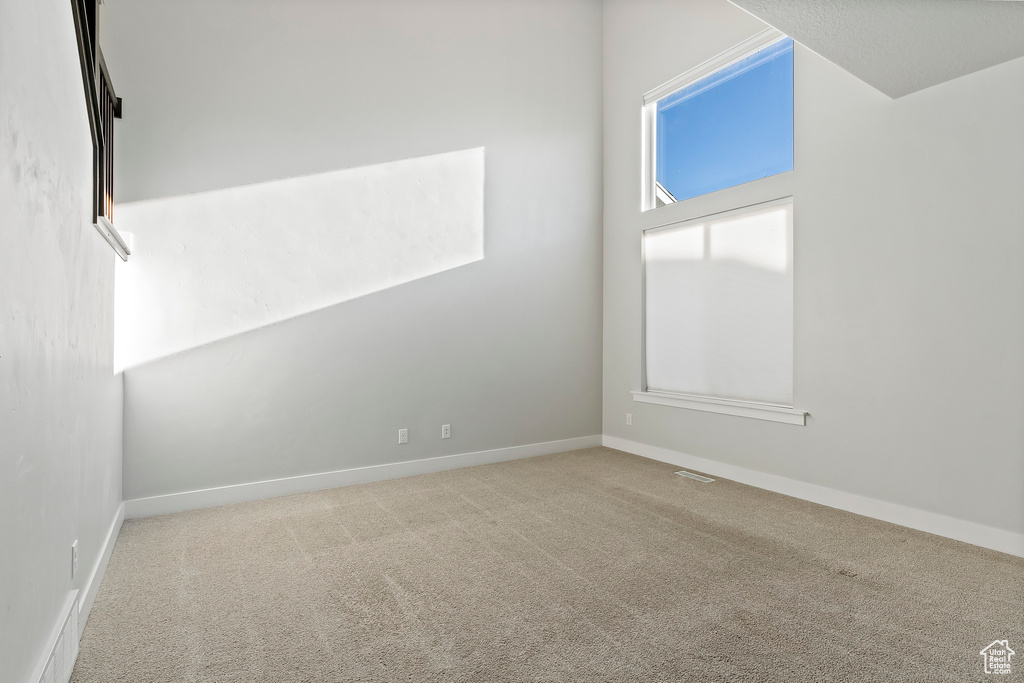 Carpeted spare room with baseboards